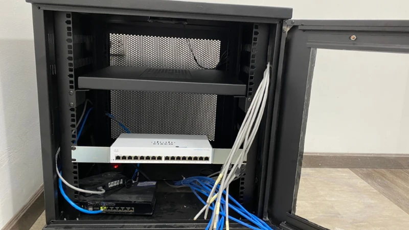 Tủ rack lắp đặt thiết bị mạng và hệ thống cáp LAN trong văn phòng.